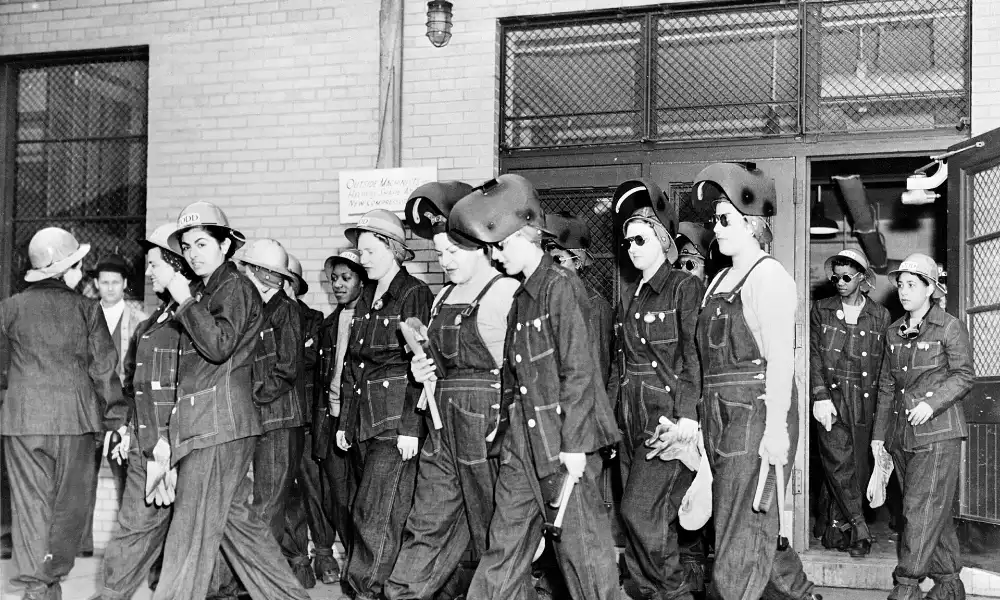 Women war workers in coveralls and helmets at a 1940s shipyard